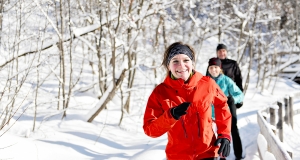 Group of friends enjoying jogging in the snow in winter